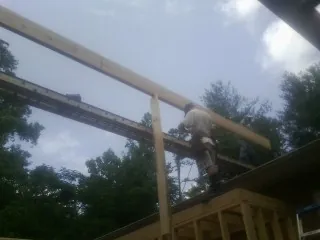 Carpenter setting a ridge beam over a new addition frame — Ice Dam Removal by Roofing Brothers in Salamanca