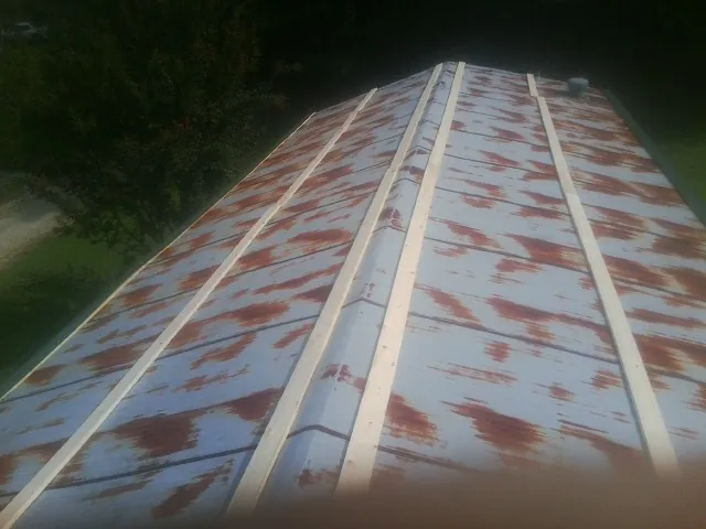 Rusted metal roof panels with new wood purlins before replacement — Storm Damage Roof Repair in Salamanca by Roofing Brothers