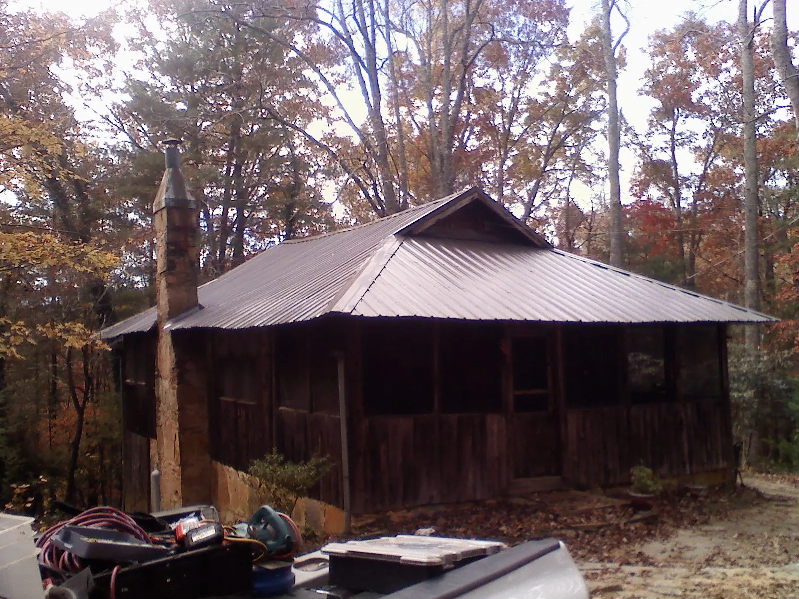 Brown metal hip roof on an old cabin with a stone chimney in Salamanca